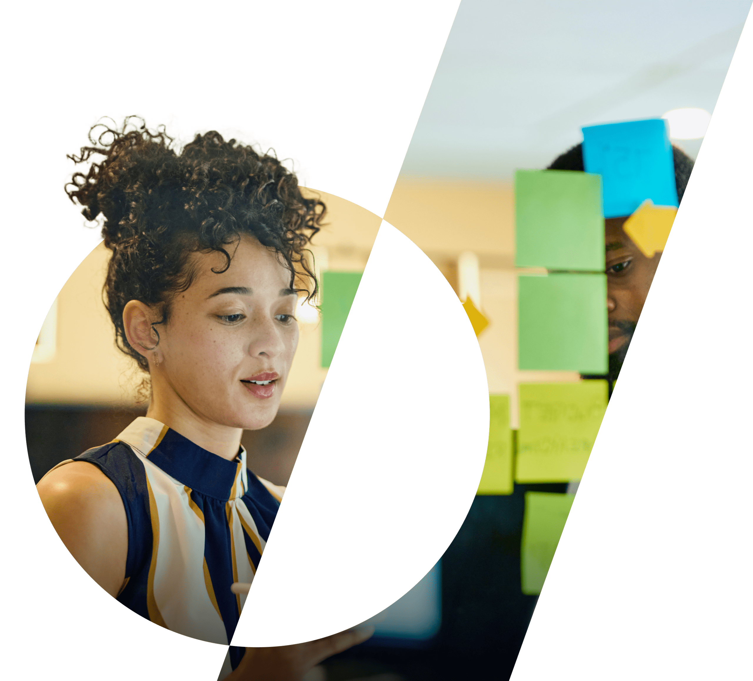 A woman and a man stand in front of a glass wall onto which they are placing sticky notes.